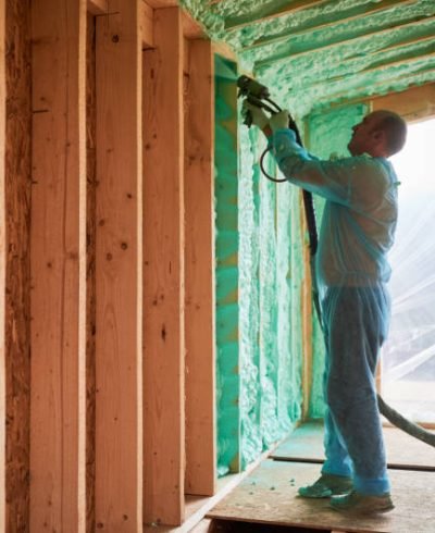 istockphoto-1394617765-612x612 Male builder insulating wooden frame house. Man worker spraying polyurethane foam inside of future cottage, using plural component gun. Construction and insulation concept.